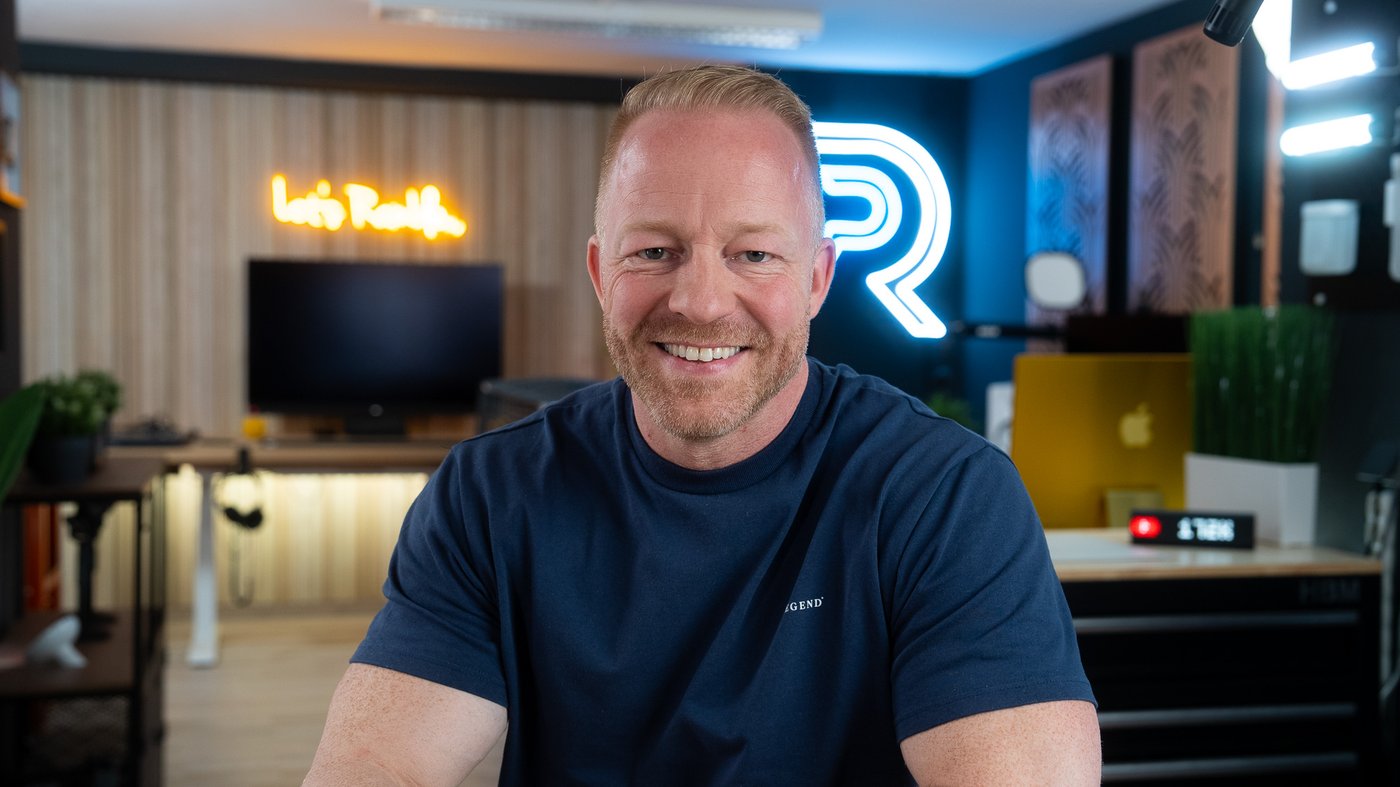Patrick in his studio, in front of the Patrick Rambles neon logo